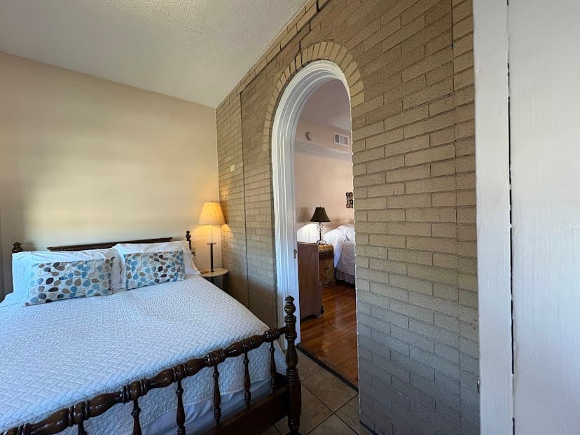 Small attached room with cherry wood double bed, lamp on side stand