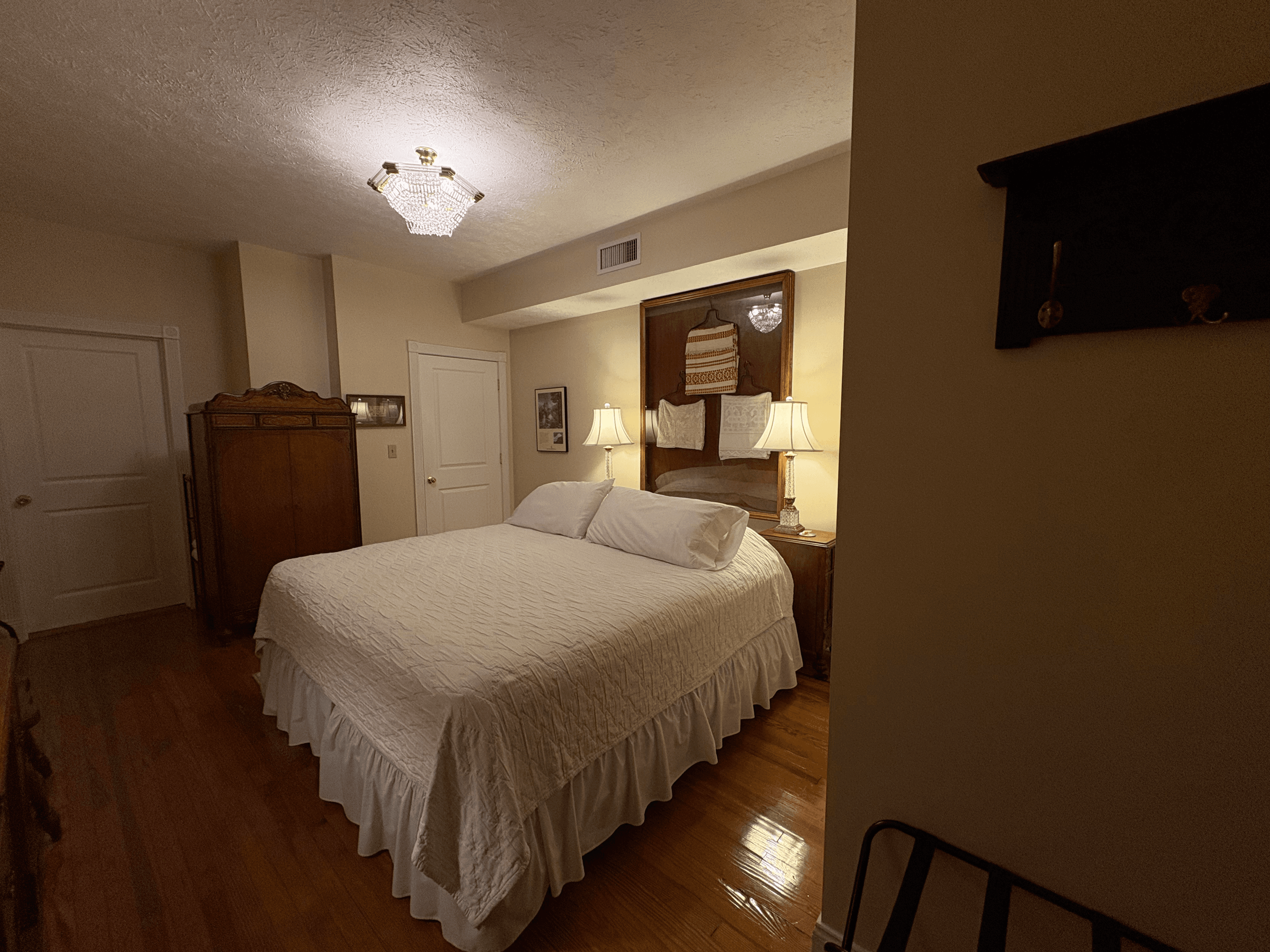 View from side of room, king bed, antique, walnut cedar wardrobe