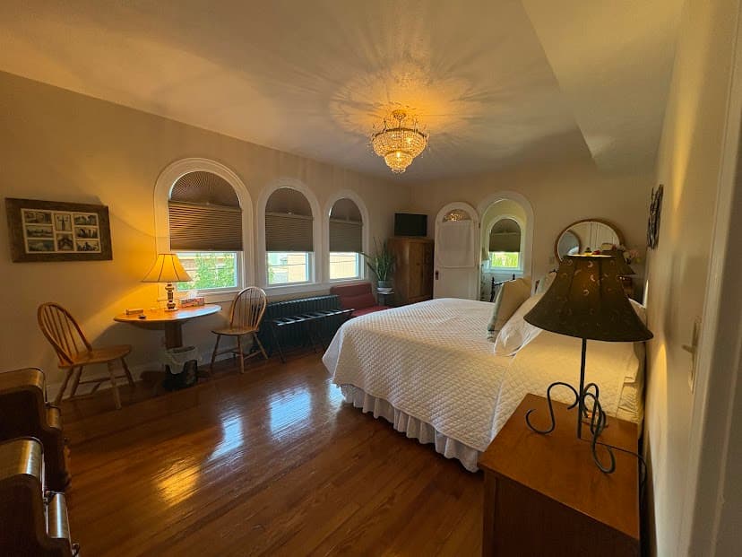 three arched windows, table 2 chairs, crystal chandelier
