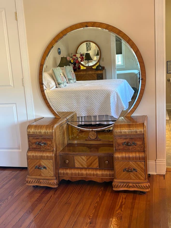 View of room from the Depression era dressing table mirror showing king bed